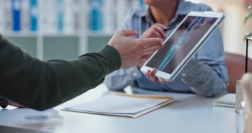 Doctor Reviews X-Ray with Patient on Tablet