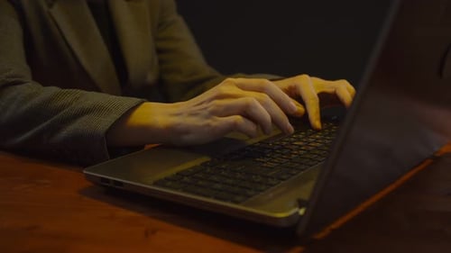 Hands Typing on Laptop Keyboard at Desk
