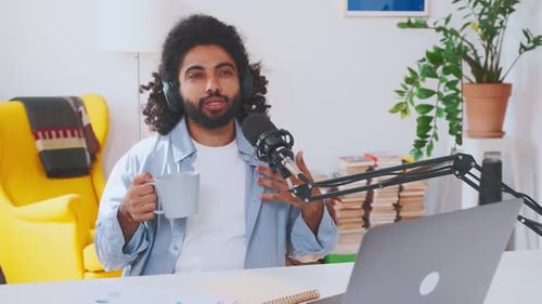 Man Podcasting at Home with Microphone and Laptop