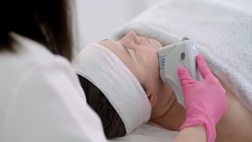 Woman Cosmetologist Performing Ultrasound Face Lift Beauty Treatment Client Lying Comfortably
