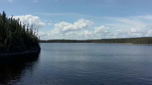 Drone flying over the waters of a wide lake in summer