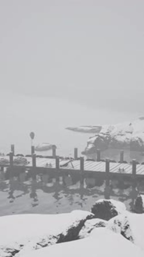 Red Building on Snow Covered Shore With Old Wooden Pier