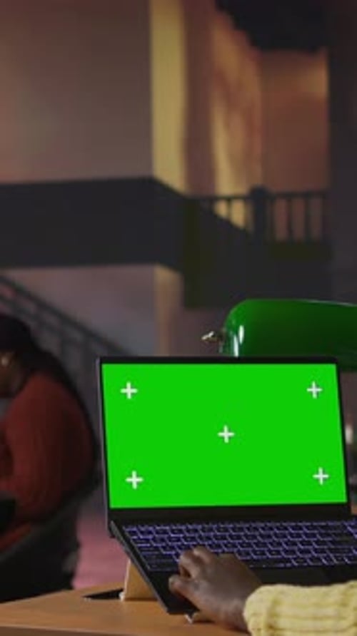 Vertical Video Black Scholar Reading Information Via Internet Next to Chroma Key in a Library