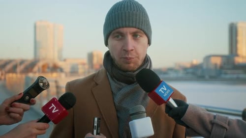 Hands of Journalists with Microphones Interviewing Male City Mayor on Bridge