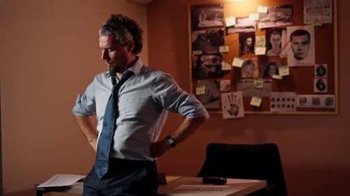 in the Detective's Office Middleaged Investigator in a Shirt and Tie Examines with a Magnifying