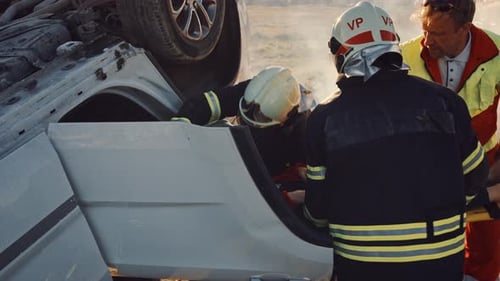 On the Car Crash Traffic Accident Scene: Rescue Team of Firefighters Pull Female Victim out of Roll
