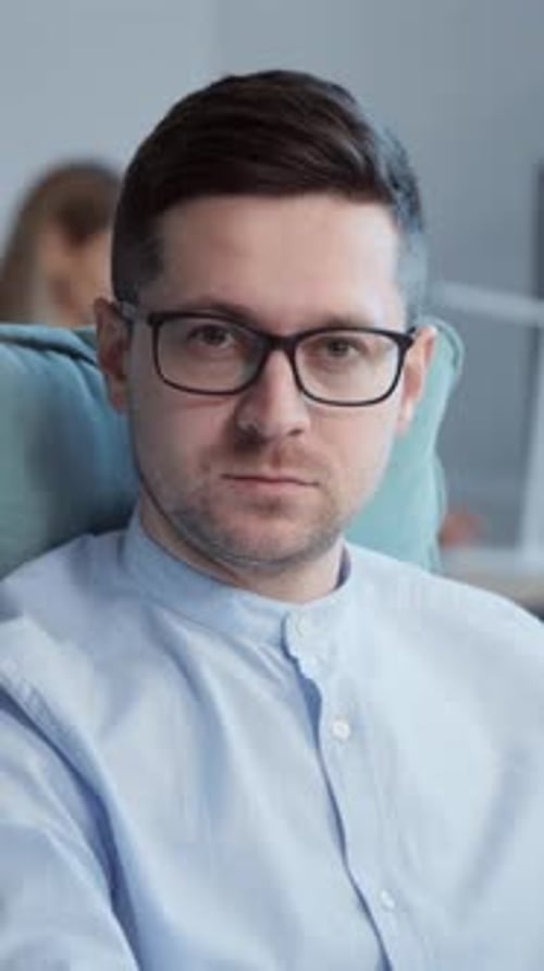 Closeup Portrait of Confident Young Office Manager Sitting at Desk in Modern Office Footage of