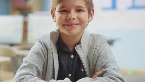 Portrait of a Cute Little Boy Sitting at his School Desk, Smiles Happily. Smart Little Boy with Cha