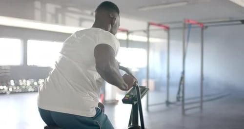 Exercising on stationary bike, man working out in gym for fitness training