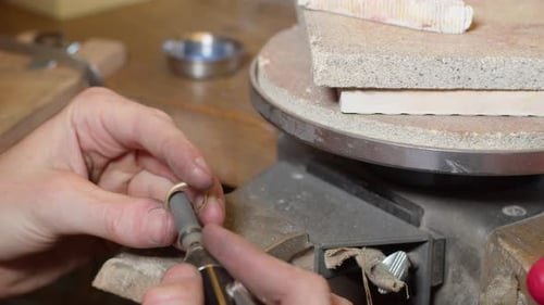 Diamond gold wedding ring in the making and getting polished on the inside by jeweller