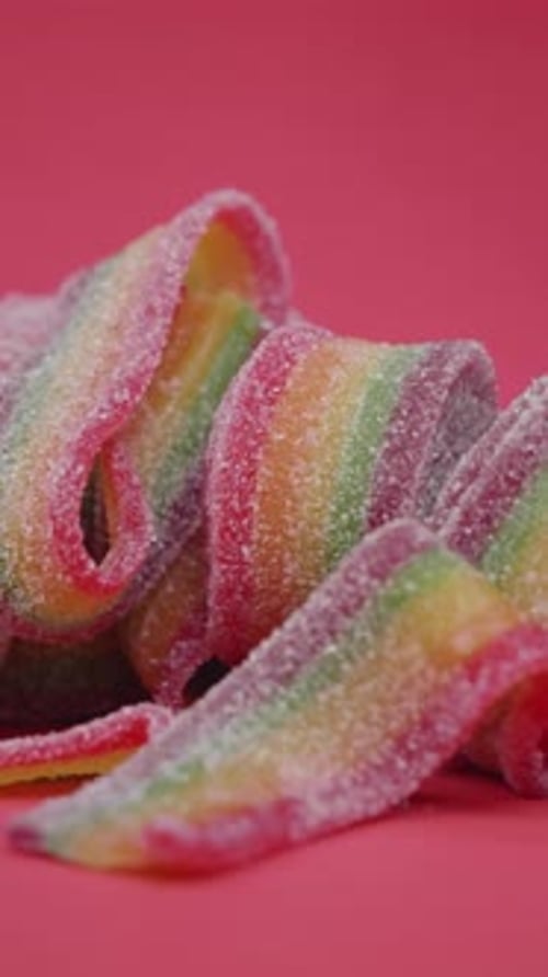 Rainbow Candy Rolls on Pink Surface Delicious Treat