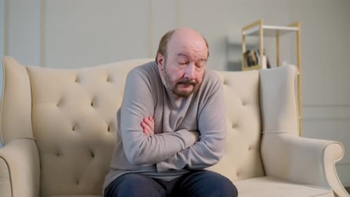Man Shivering on Couch