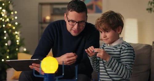 Father and Son Play with Solar System Toy