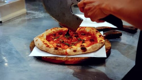 Authentic pizza making process in traditional Italian pizzeria, with the chef cutting the pizza