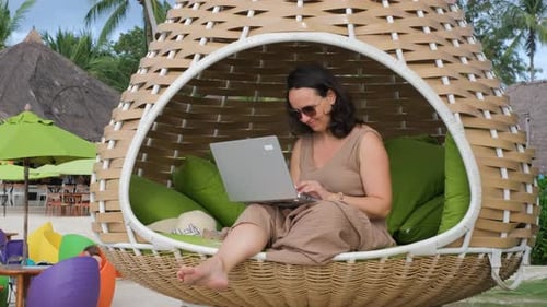 Freelancer feminina trabalha em laptop em praia panorâmica