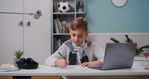 Boy Drawing While Looking at Laptop Computer