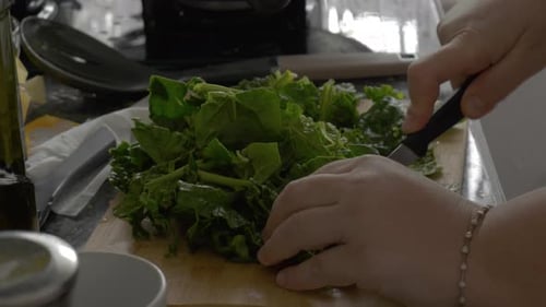 Sauteing Fresh Green Spinach with Wooden Spoon in Pan