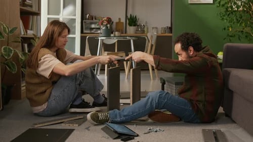 Mature Couple Giving High Fives while Assembling Drawer Together at Home