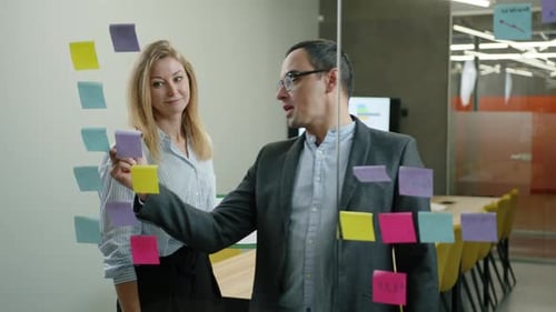 Adults Brainstorming With Sticky Notes In Modern Office