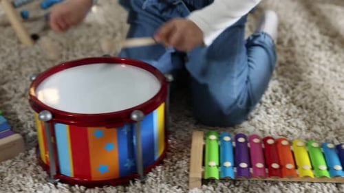 Child Plays Music on Xylophone and Toy Drum