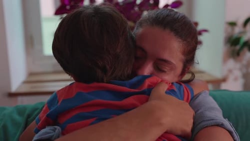 Tender Moment: Mother and Child Embrace on Sofa