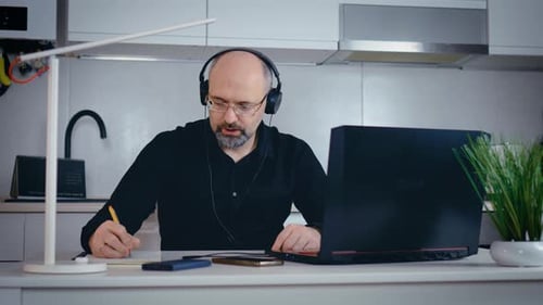 Man working on laptop in bright, modern kitchen