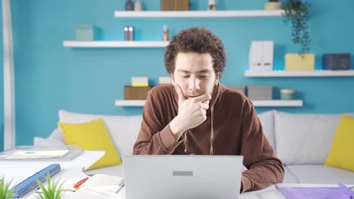 Young college student studying at home is bored, bored with studying too much.