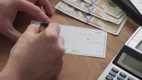 Closeup of Man Writing a Check at Home
