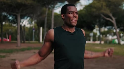 Muscular Man Stretching in the Park