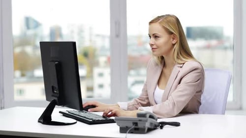 Blonde Woman Working at Computer and Answering Phone