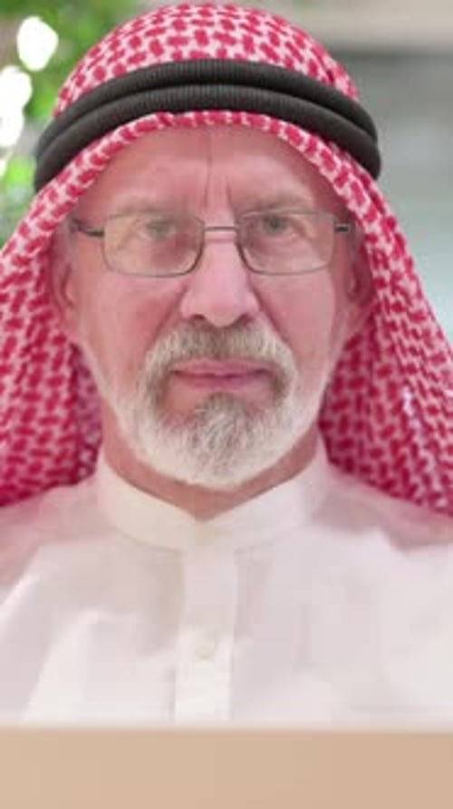 Senior Man Wearing Traditional Headdress Smiles at Camera
