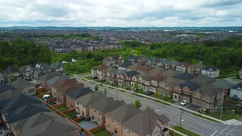 Aerial view of suburban neighborhood, flying upwards while panning down on houses
