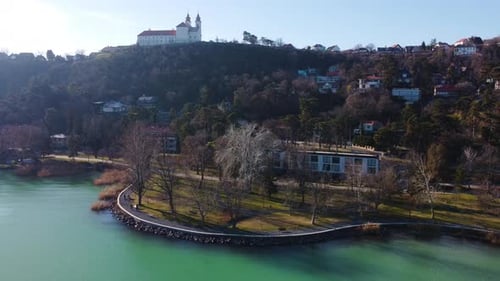 Aerial orbit of Tihany Monastery above shimmering lake