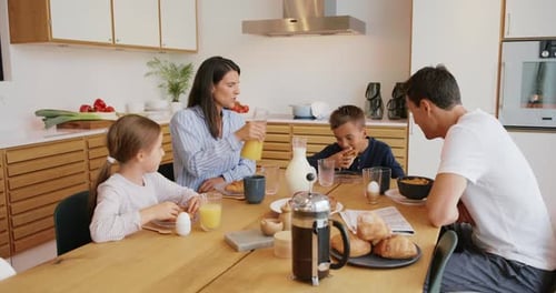 Family eating breakfast together at kitchen table