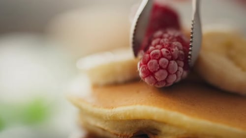 Delicious Pancakes Topped with Banana and Raspberries