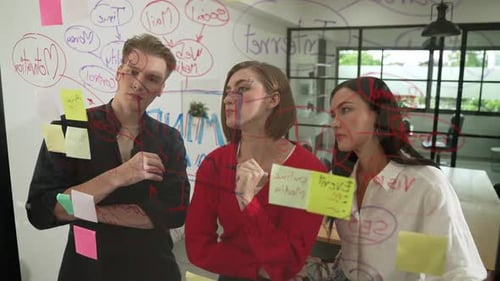 Three Young Adults Brainstorm Ideas in Modern Office