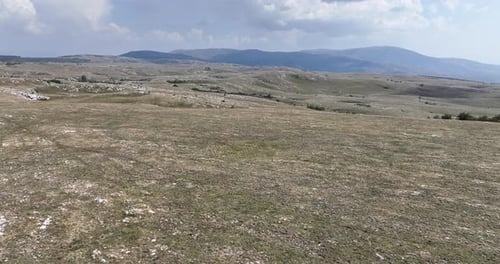 Aerial View of Rolling Hills and Distant Mountains