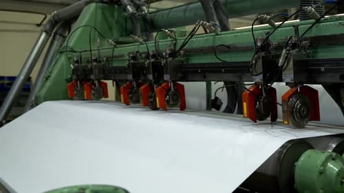 Papierblatt wurde in der Werkswerkstatt zwischen Metallrollen bewegt