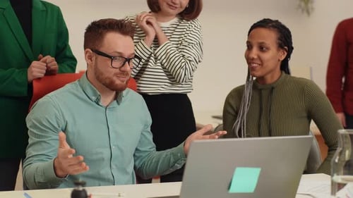 Diverse Team Applauds Success at Office Desk