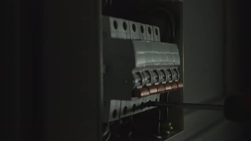 Electrician Assembles Electrical Panel in Dark