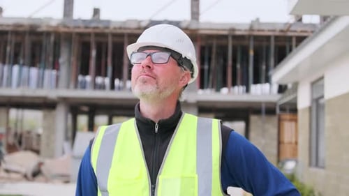 Ingeniero caucásico seguro de sí mismo comprobando la inspección en la construcción de viviendas modernas.