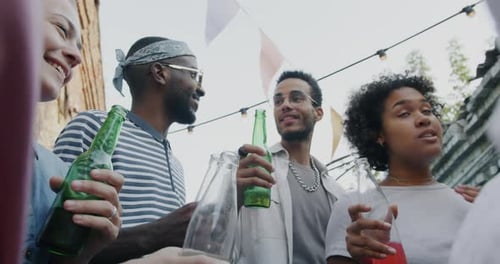 Young Friends Toasting With Bottles Outdoors