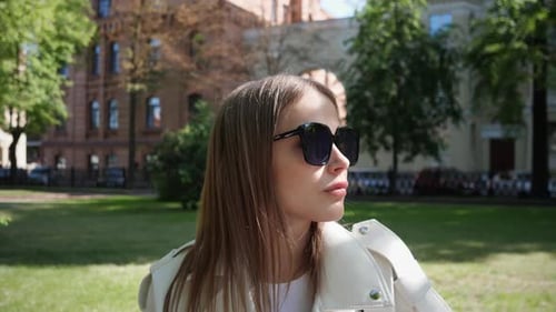 Stylish Woman with Sunglasses in Urban Park