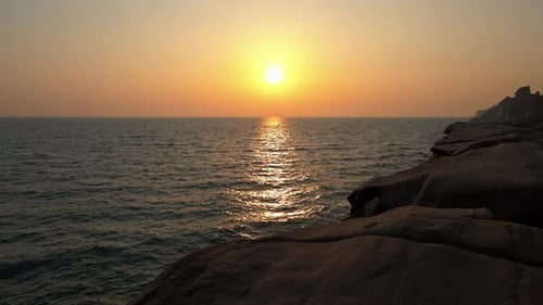 Breathtaking Sunset Over the Ocean with Rocky Shoreline in 4K