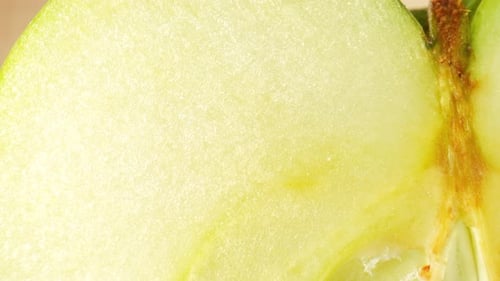 The camera focuses on the half green apple. Macro footage