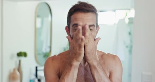 Handsome Man Applying Moisturizer in Bathroom Mirror