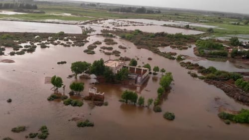 Aerial drone rotating shot over a village house submerged under river water after severe river flood