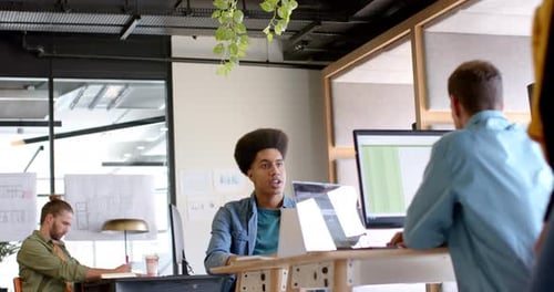 Young Caucasian man works on a computer in a modern, casual business office