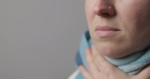 Woman Using Throat Spray in Close Up Studio Shot