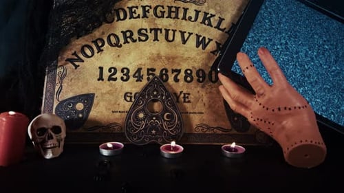 Spooky Ouija Board with Candles and a Hand